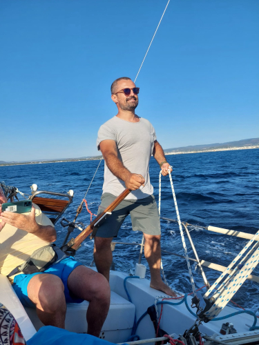 Skipper führt Manöver beim Segeln in Alghero durch