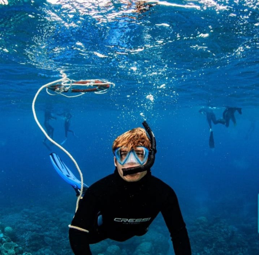 Turista si immerge durante il tour di snorkeling a Capo Testa