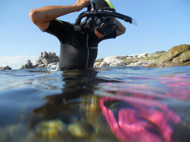 Tourist about to dive into the waters of Capo Testa