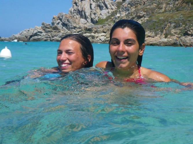 Tourists snorkelling in the crystal-clear waters of Capo Testa