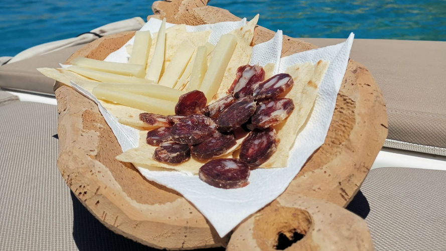 Aperitif mit lokalen Produkten, serviert an Bord des Schlauchboots in Olbia