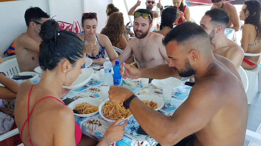 Ospiti a bordo del tour si godono il pranzo con il pescato del giorno