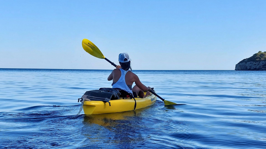 Hiker paddles in the bay of Porto Conte during the tour