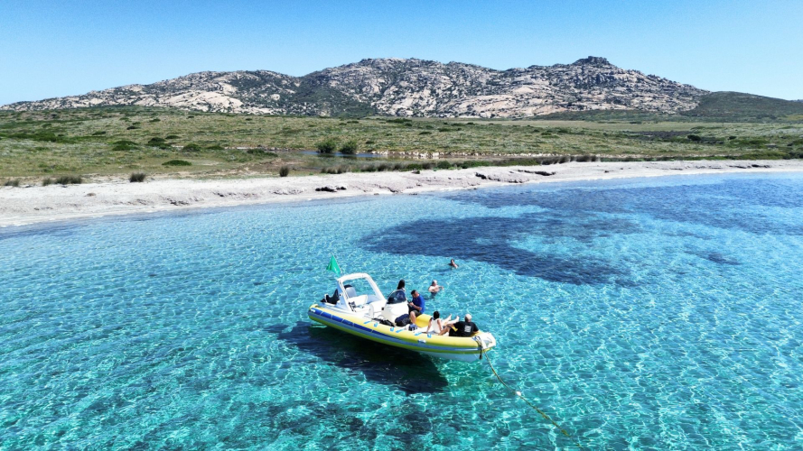 Bateau pneumatique naviguant dans les eaux cristallines de Stintino