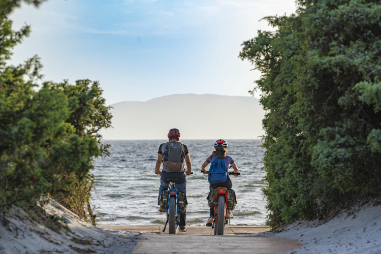 Radfahrer machen während ihrer Radtour durch den Süden Sardiniens Halt am Strand