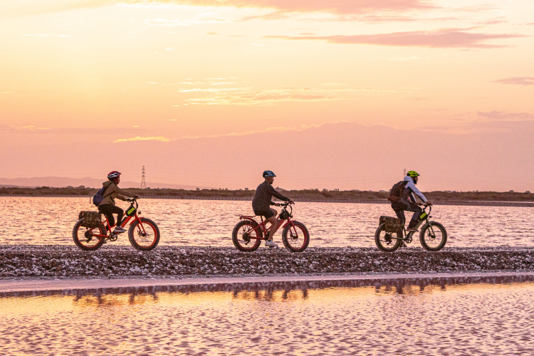 Radfahrer machen während ihrer Radtour durch den Süden Sardiniens Halt am Strand
