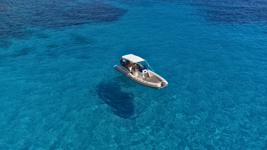 Gommone naviga nelle acque cristalline di Cala Biriala
