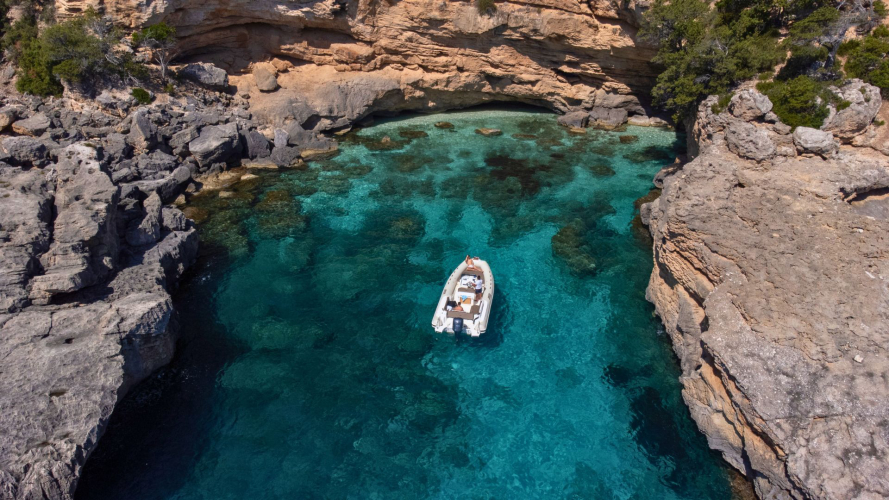 Gommone naviga nella costa di Baunei