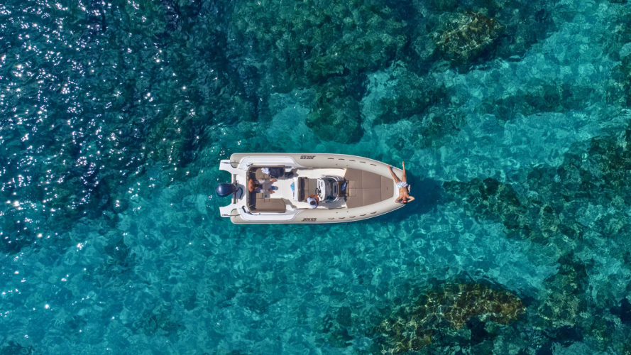 Gommone naviga nelle acque cristalline di Cala Mariolu