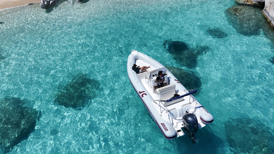 Gommone naviga nelle acque cristalline di Cala Luna