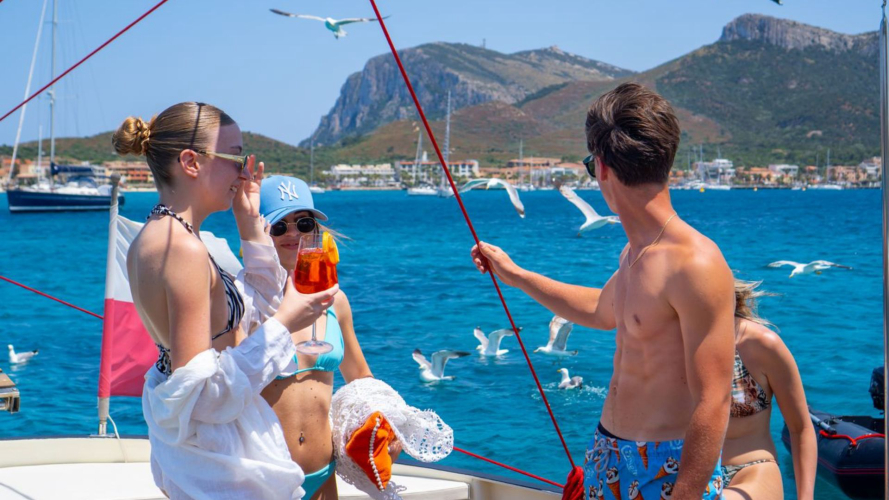 Ragazzi fanno aperitivo a bordo della barca a vela a Molara