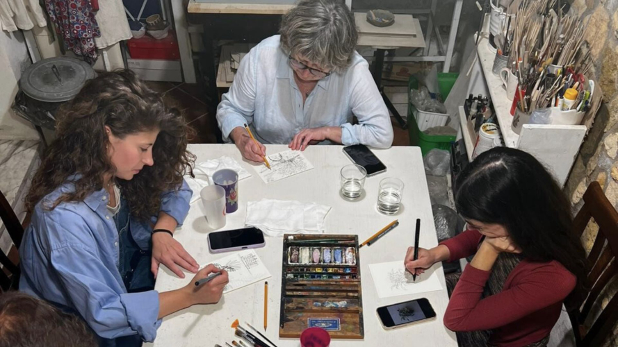 Mädchen bemalen Postkarten mit Aquarellfarben im Süden Sardiniens