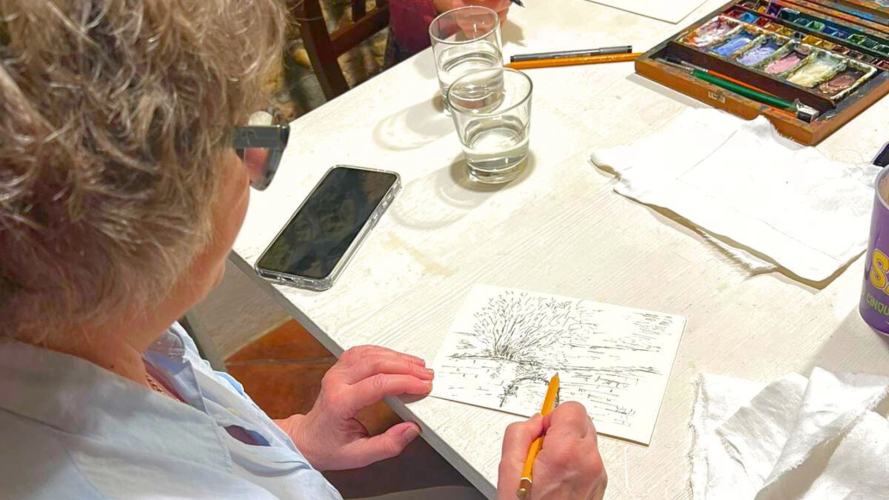 Frau malt eine Postkarte während des Workshops in Cagliari