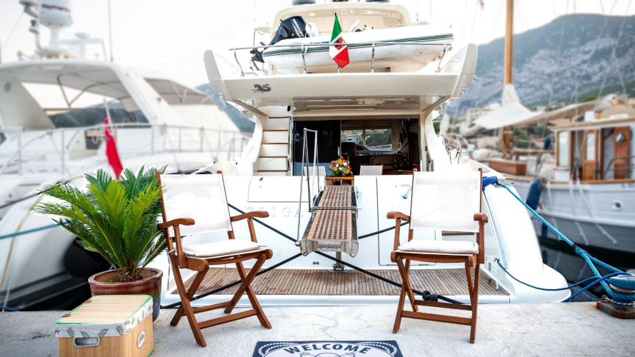 Yacht di lusso ormeggiato a Porto Cervo, con due sedie e una pianta in primo piano