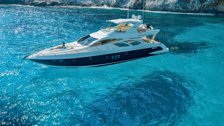 Yacht di lusso in navigazione con persone a bordo e altre in acqua nelle vicinanze