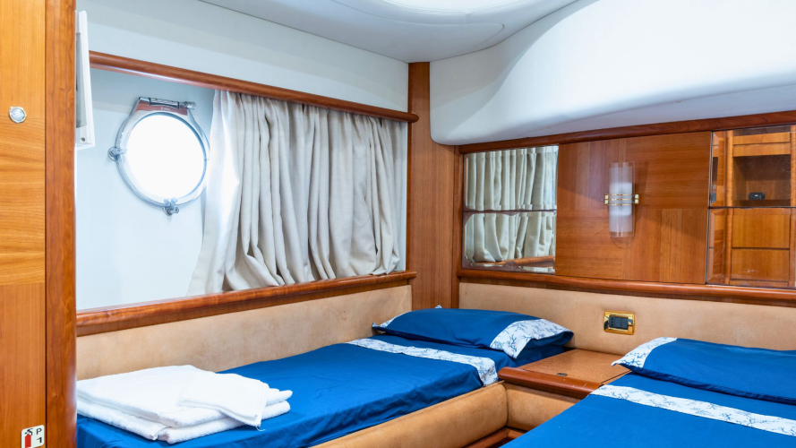 Interni di un yacht di lusso con due letti matrimoniali, finestre e un oblò in Costa Smeralda