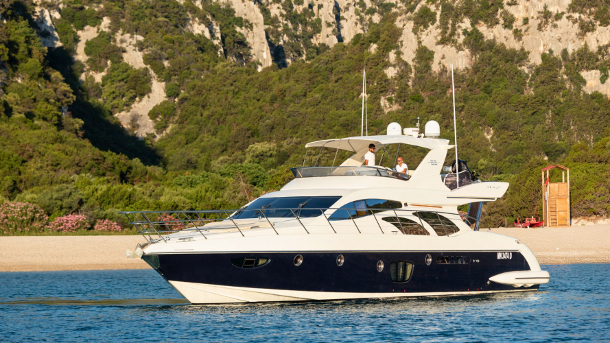 Yacht di lusso ormeggiato vicino alla costa con persone a bordo