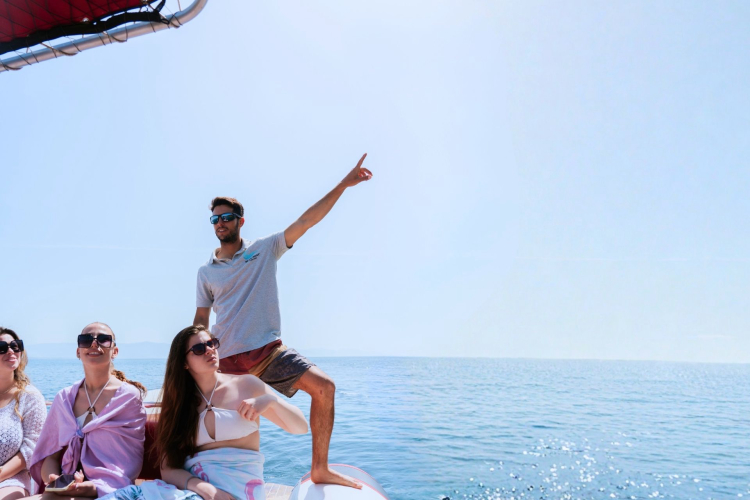 Lo skipper illustra la costa di Cagliari ai viaggiatori a bordo