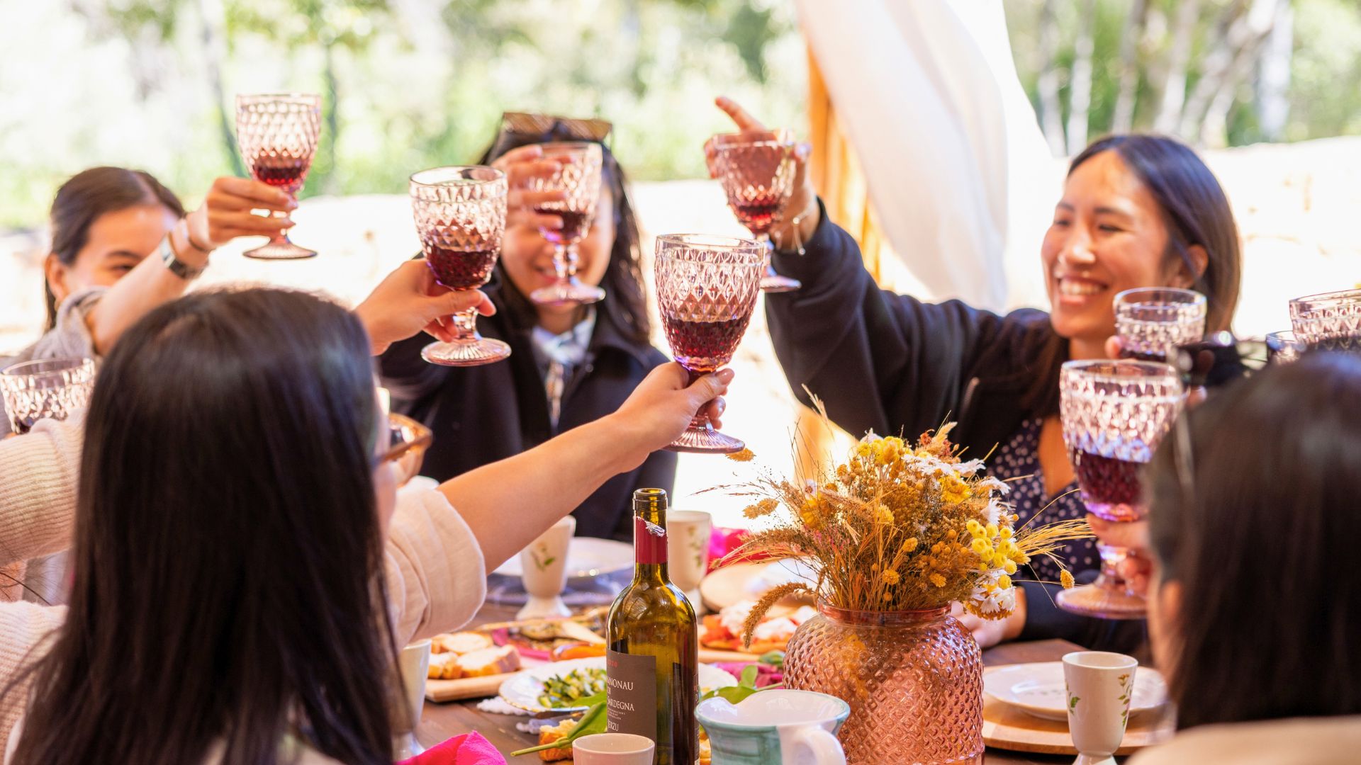 Groupe de personnes dans un espace extérieur, avec des tables et de la nourriture, en train de griller