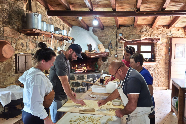 Un gruppo di persone lavora insieme in una cucina rustica, scoprendo i segreti della longevità