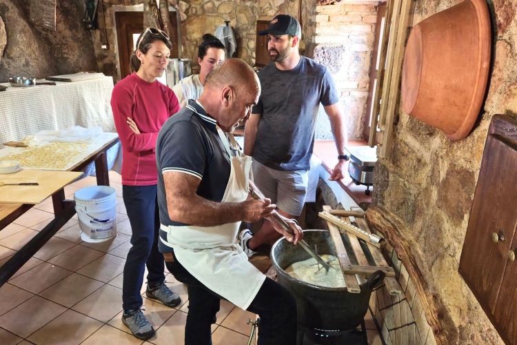 Gruppo di persone nella casa di un pastore assistono alla dimostrazione del formaggio