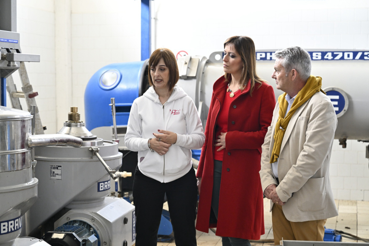 Deux personnes écoutent les explications du guide dans l'une des salles de production