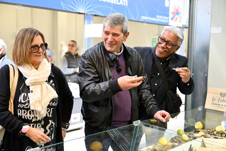 Los visitantes degustan productos de pescado fresco durante la degustación en el mercado de Cagliari