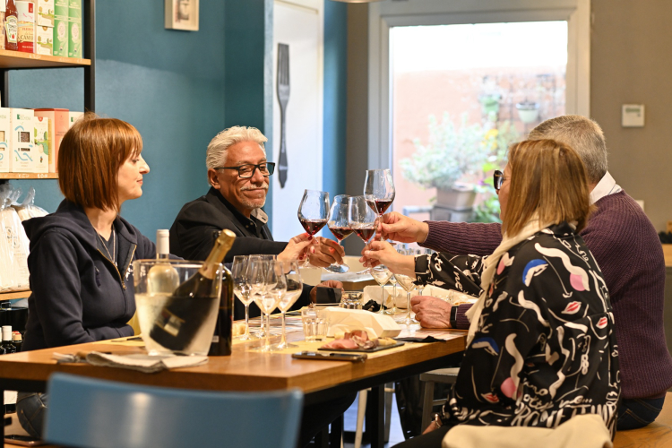 Gente brindando durante una degustación de vinos en el centro de Cagliari