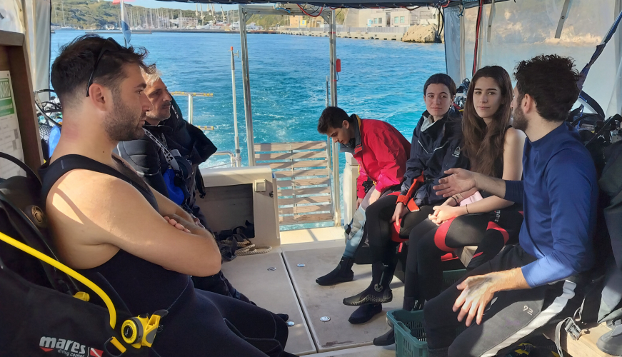 Gruppo di persone si dirige in barca verso uno dei punti di immersione a Santa Teresa