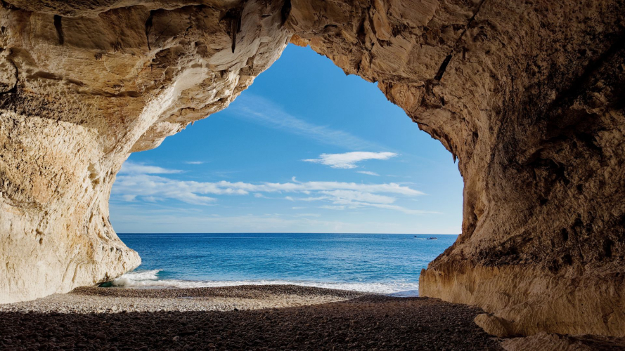 Vista da una delle grotte di Cala Luna e il mare cristallino della costa orientale della Sardegna