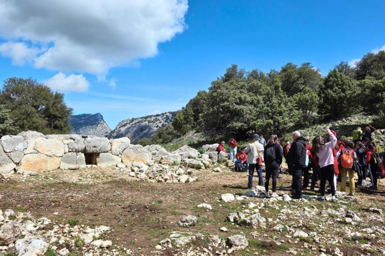 Gruppo di persone in visita ad un sito archeologico in Sardegna con un accompagnatore locale