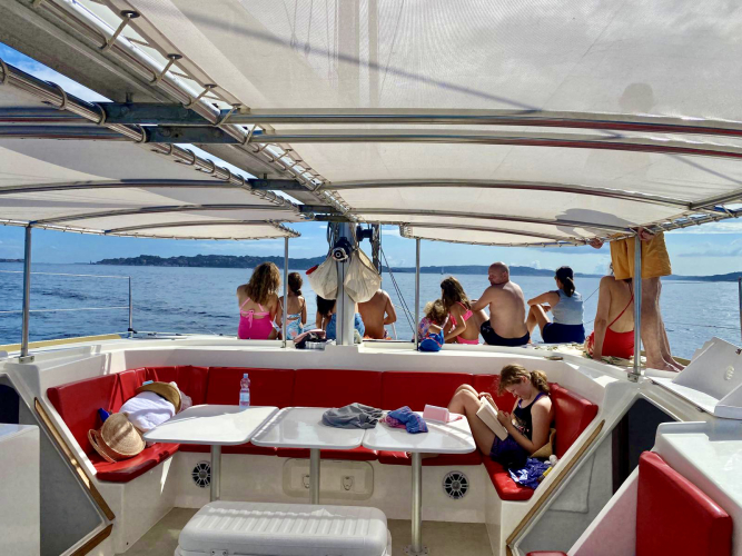 las personas a bordo del catamarán se relajan durante el recorrido a La Maddalena