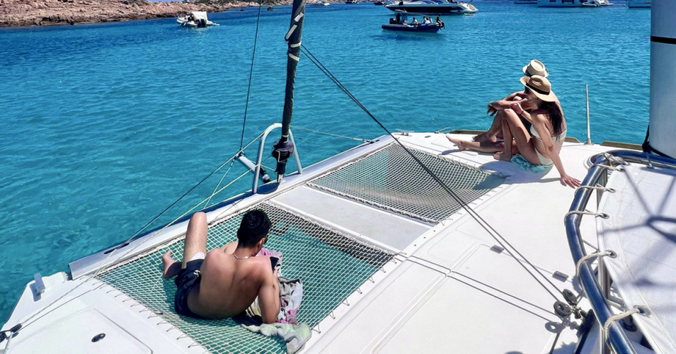 Las personas a bordo del catamarán toman el sol durante el recorrido