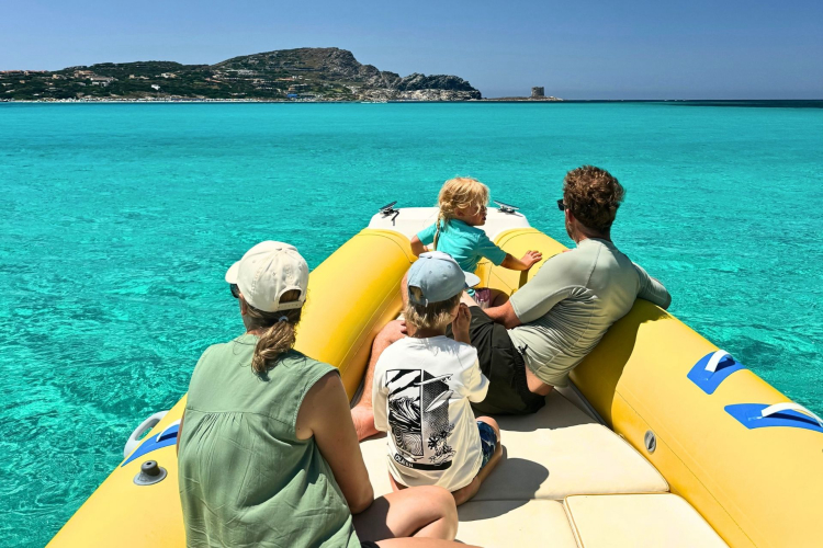Family on a dinghy tour in the turquoise sea of Stintino in front of La Pelosa