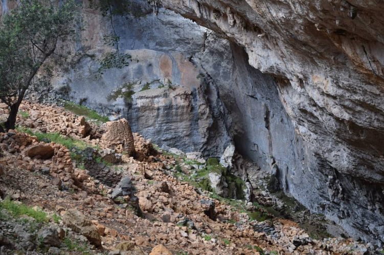 Image d'un paysage montagneux avec de la roche, de la végétation et un gouffre naturel ouvert
