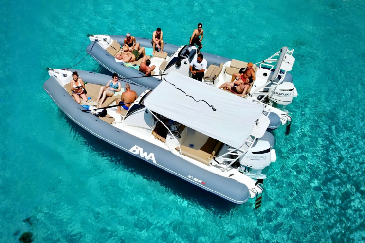 Eine Gruppe von Menschen auf einem Beiboot im transparenten Wasser des La Maddalena-Archipels