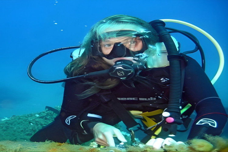 Una ragazza esplora il fondale durante la sua prima immersione a Santa Teresa