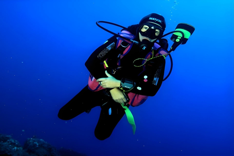 Un subacqueo con attrezzatura completa si immerge nelle acque vicino a Santa Teresa di Gallura