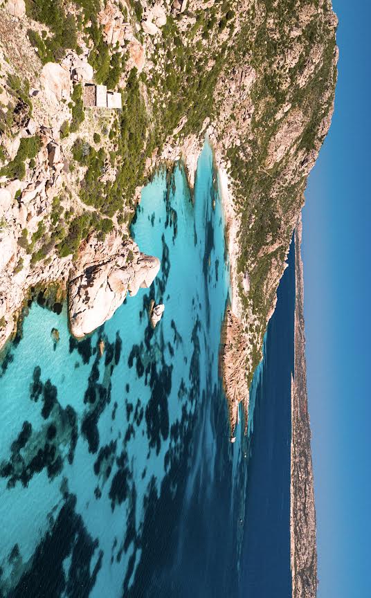 Imagen de un viaje en barco por el archipiélago de La Maddalena con aguas turquesas y un paisaje natural virgen