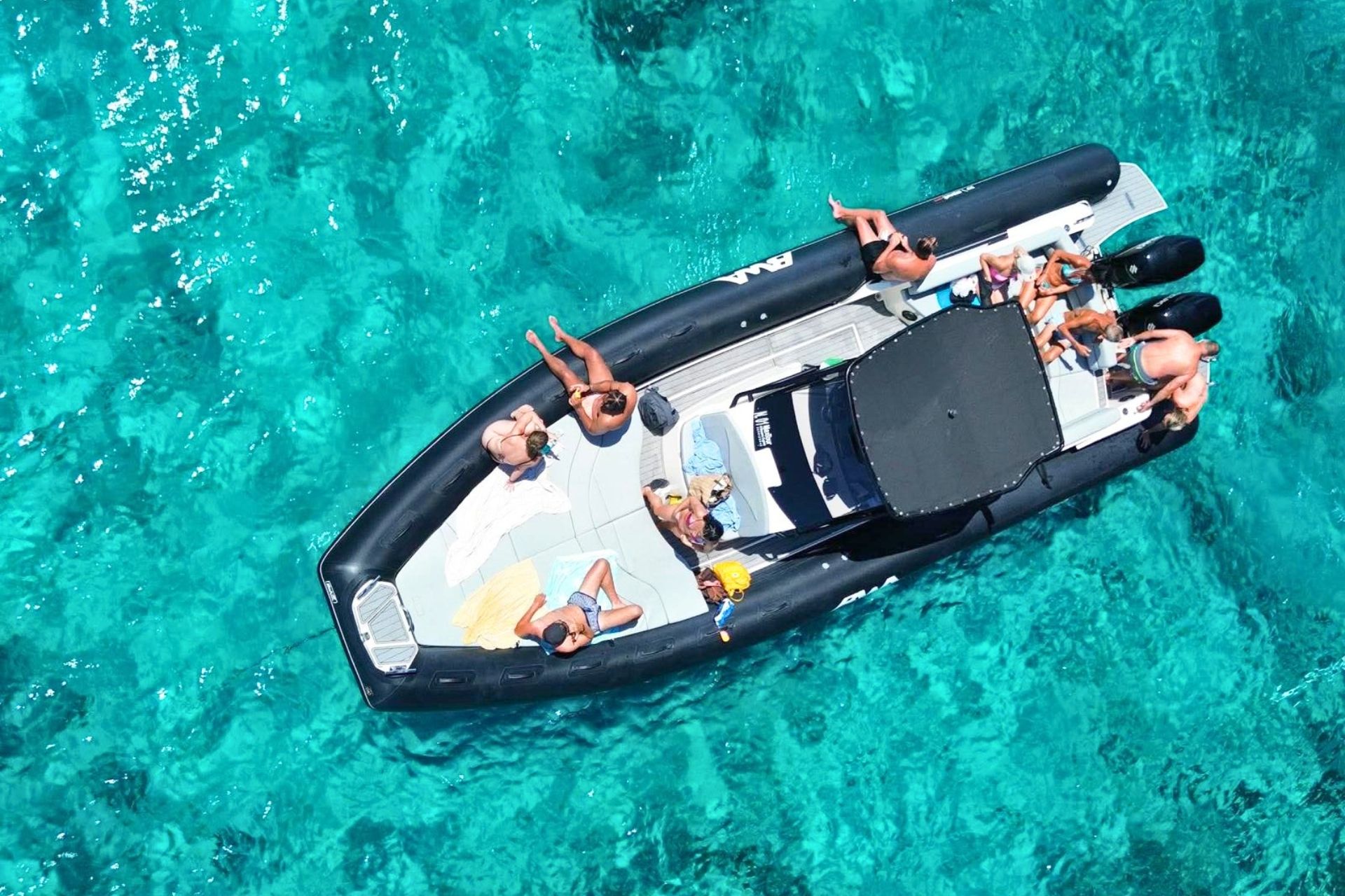 Gruppe von Menschen auf einem Beiboot, umgeben von kristallklarem Meer in La Maddalena