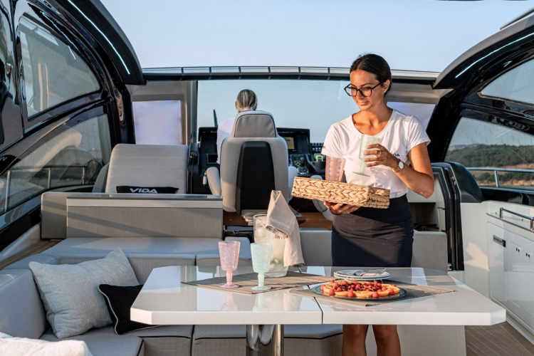 Die Stewardess, die während der privaten Tour einen Aperitif auf der Yacht serviert