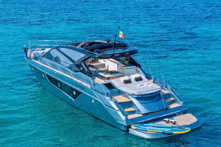 Luxusyacht vor Anker in kristallklarem Wasser mit Schnorchelzubehör und einem Ruhebereich an Bord.