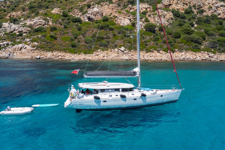 Un monomarano a vela naviga in acque cristalline verso l'arcipelago di La Maddalena