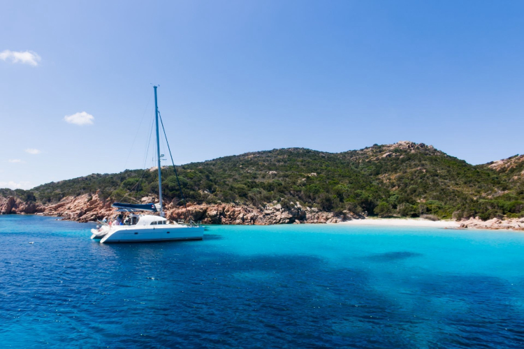 Catamaran naviguant dans des eaux turquoises avec des îles en arrière-plan
