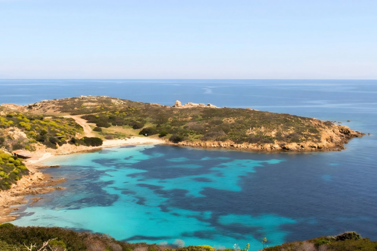 Image of a rocky coast with blue water and green vegetation, ideal for an ebike tour.