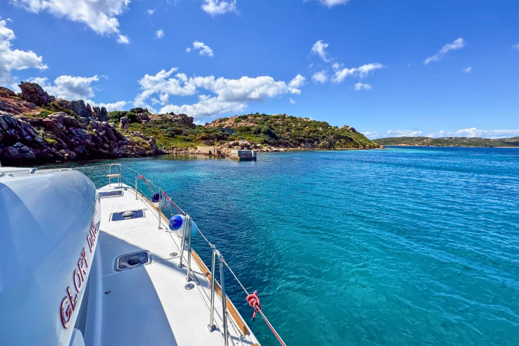 Catamaran moored in a bay with cliffs and islands in the background.