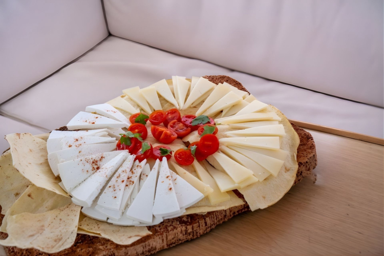 A plate of cheese and vegetables on a table, with an atmosphere of relaxation and fun.
