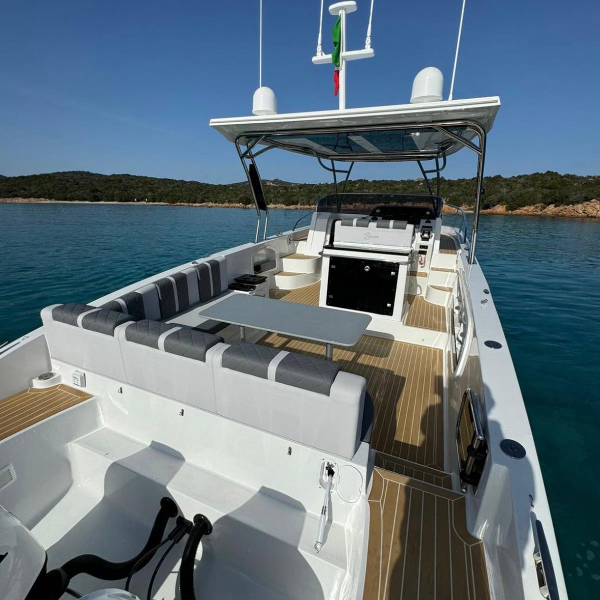 Innenraum eines privaten Bootes mit Sitzen und Tisch, das zwischen den Inseln La Maddalena und Tavolara segelt.