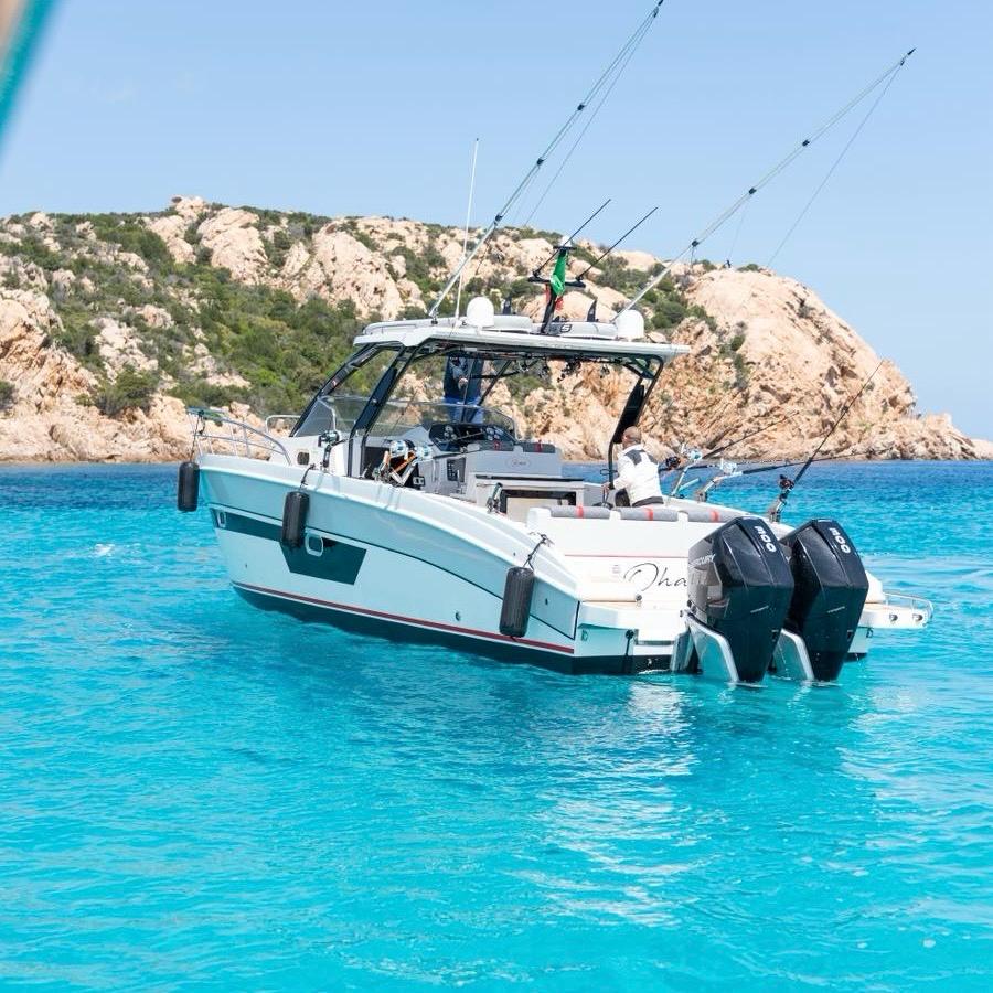 Un moderno barco de pesca deportiva con equipo profesional navega en aguas cristalinas en el noreste de Cerdeña.