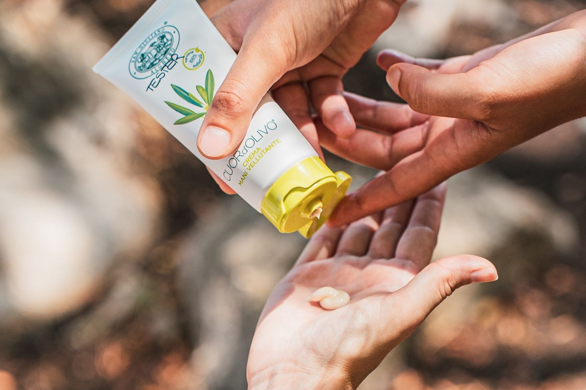 Una persona que vierte aceite en una mano, probablemente para una degustación en un olivar.